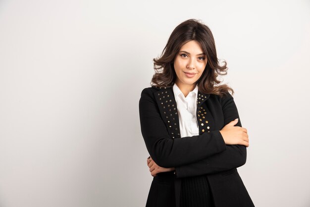 Positive woman in black jacket posing on white.