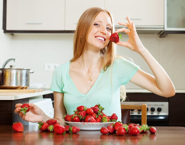 Positive woman eating strawberry