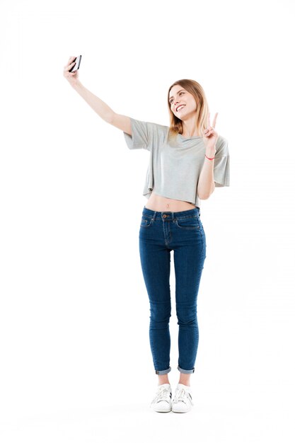 Positive woman making selfie on smartphone