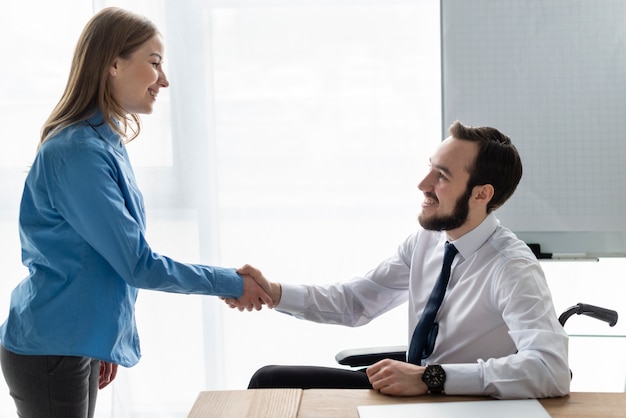 Positive woman and man shaking hands together
