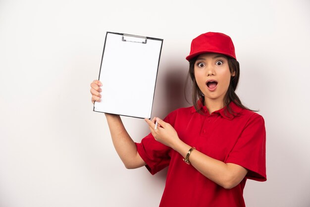 Positive woman in red uniform with empty clipboard .