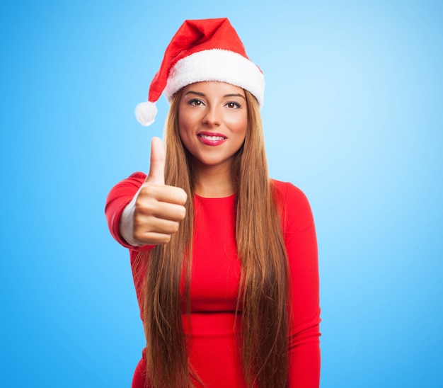 Positive woman with santa hat on blue background
