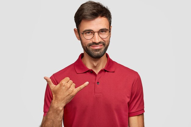 Positive young emotional man posing against the white wall