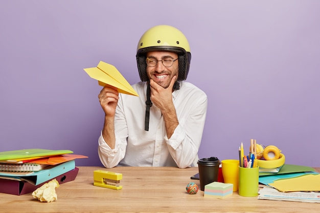 Positive young employee sitting at the office desk