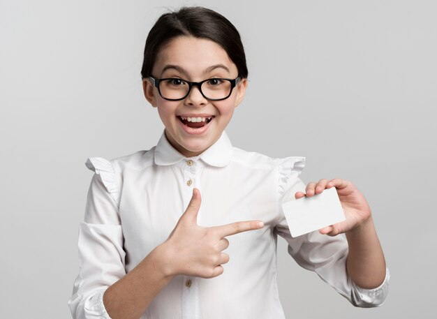 Positive young girl holding business card