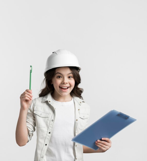 Positive young girl holding clipboard