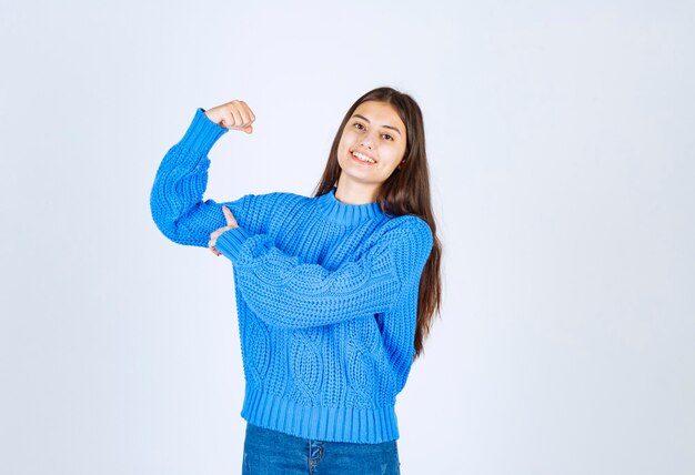 positive young girl model pointing at her bicep.