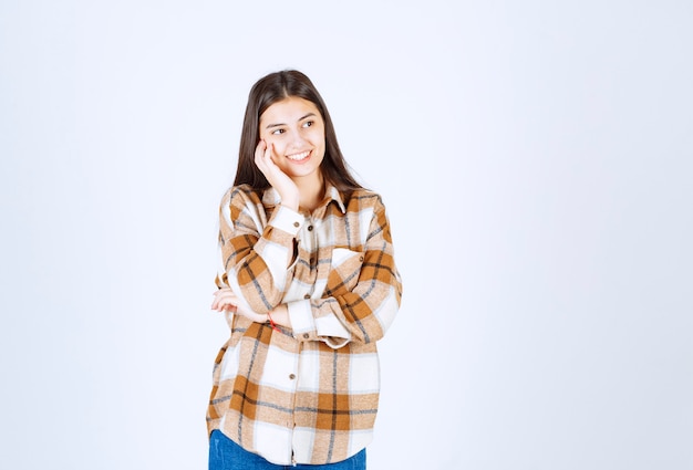 Un modello di ragazza positiva in piedi e guardando lontano.