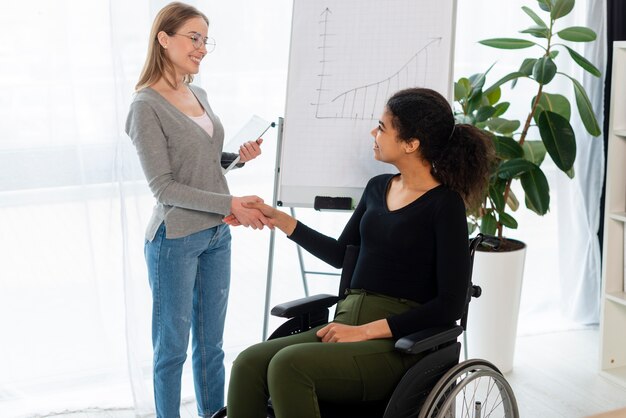 Positive young women shaking hands