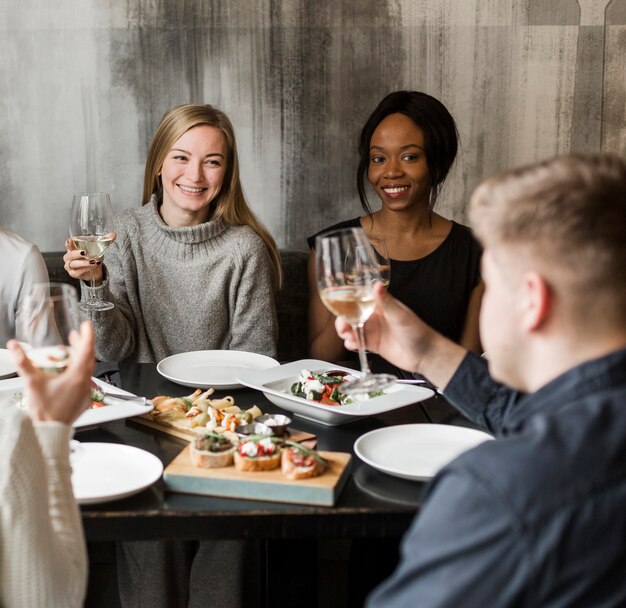 Positive young women smiling at dinner party