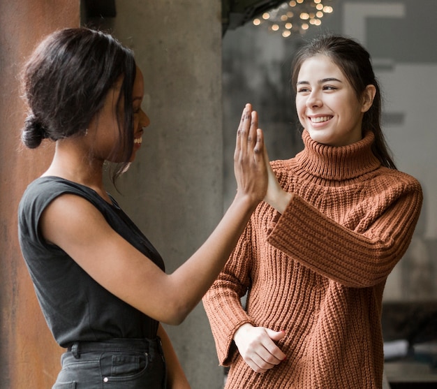 Positive young women touching hands