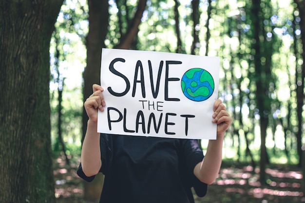 森の中で女性の手で地球を救うための呼びかけのポスター