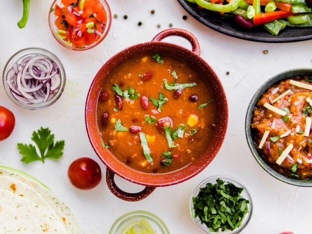 Pot of chili next to Mexican snacks