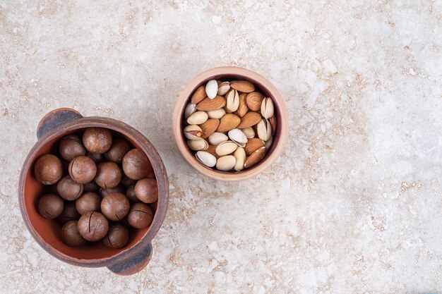 A pot of chocolate balls and a small bowl of assorted nuts 