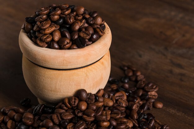 Pot with coffee beans on table