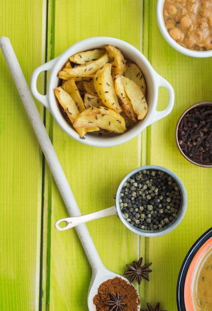 Pot with fried potatoes near spices