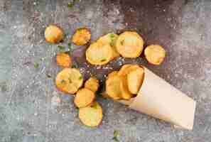 Foto gratuita patatine fritte in sacco di carta sul fondo del cemento