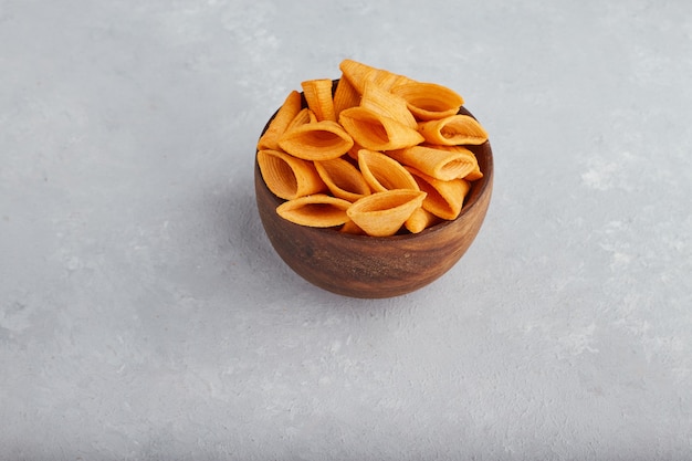 Potato chips in wooden bowl in the middle. 