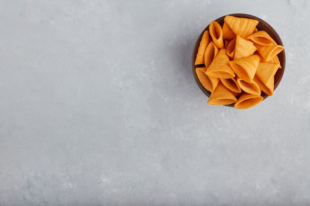 Potato chips in wooden bowl, top view. 