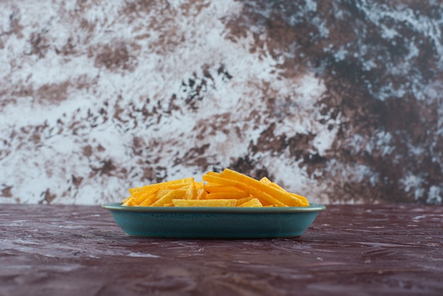 Foto gratuita patatine fritte in un piatto, sul tavolo di marmo.