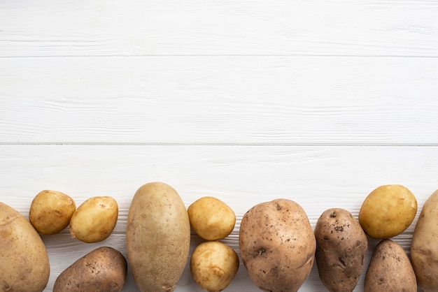 Free photo potatoes aligned on table with copy-space