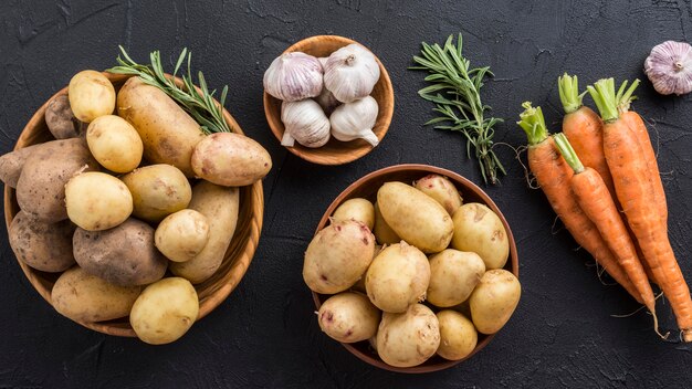 Potatoes garlic and carrot on table