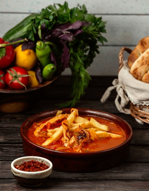 Potatoes with chicken in a sauce on a wooden table