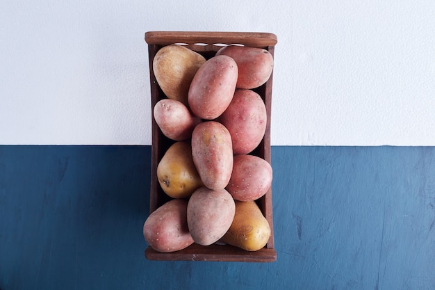 Potatoes in a wooden tray.