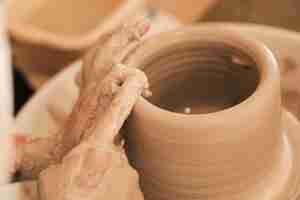 Foto gratuita potter che fa un vaso di ceramica sulla ruota di ceramica