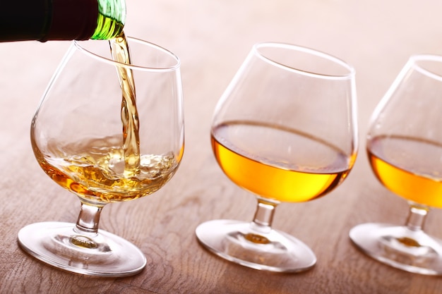 Foto gratuita versare il cognac nel bicchiere