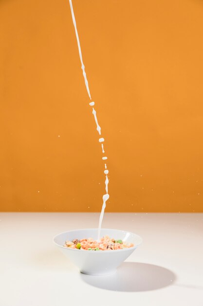 Pouring milk over the bowl with cereals