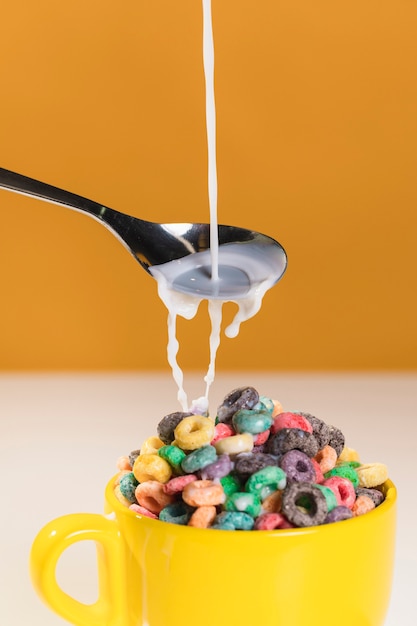 Pouring milk over bowl with cereals