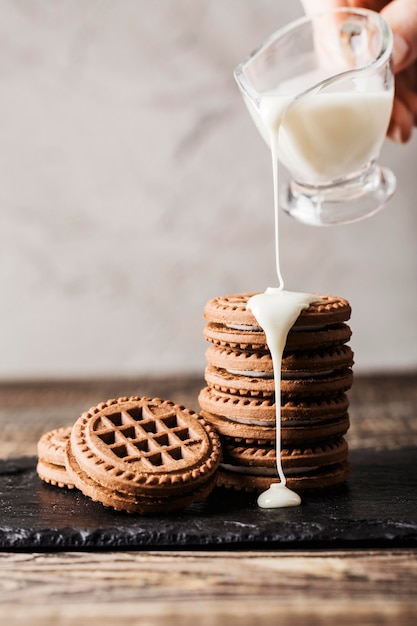 pouring milk on chocolate biscuits stack