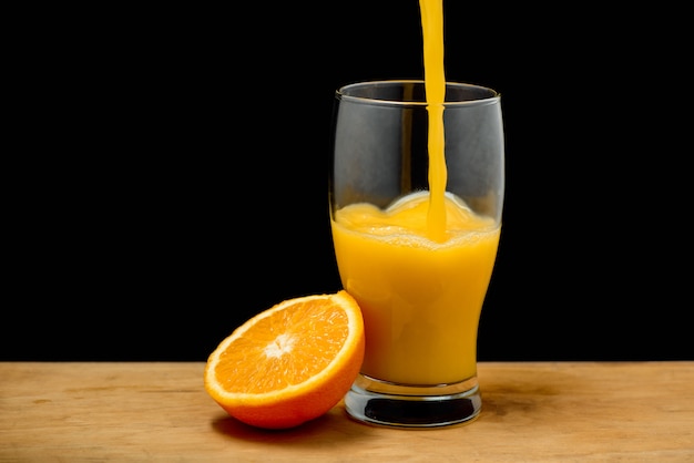 Лить апельсиновый сок в стакан
