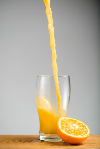 Лить апельсиновый сок в стакан