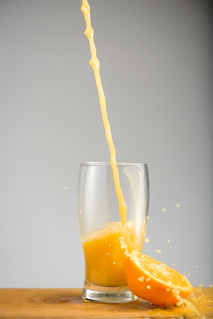 Foto gratuita versare il succo d'arancia nel bicchiere