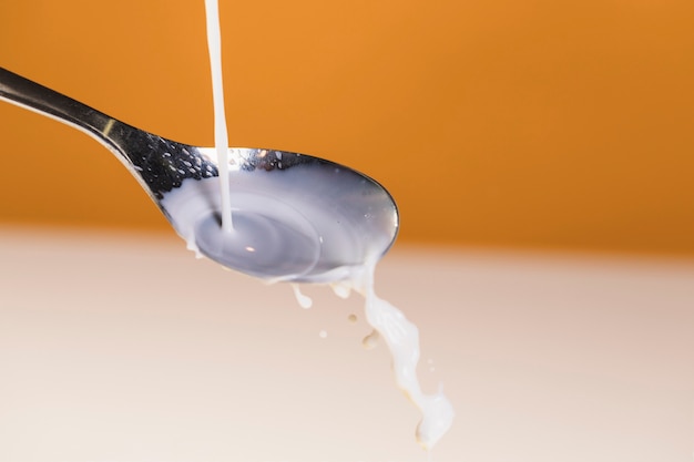 Pouring organic milk in spoon