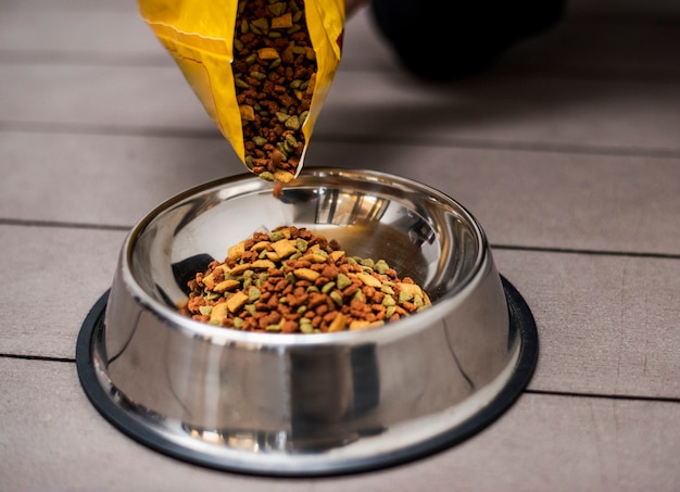 Free photo pouring pet food into a bowl