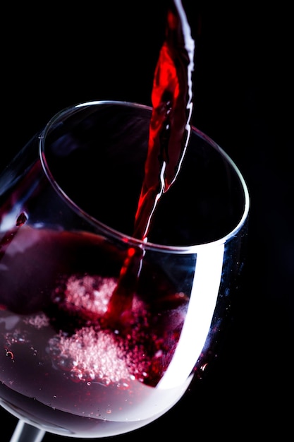 Наливая красное вино в бокал