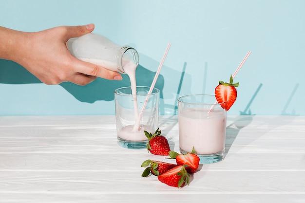 Pouring strawberry yogurt in glasses