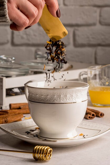 Pouring tea herbs in cup