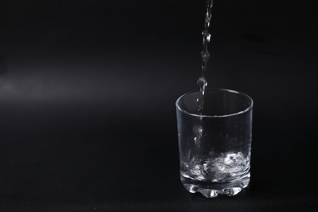 Pouring water into an empty glass.