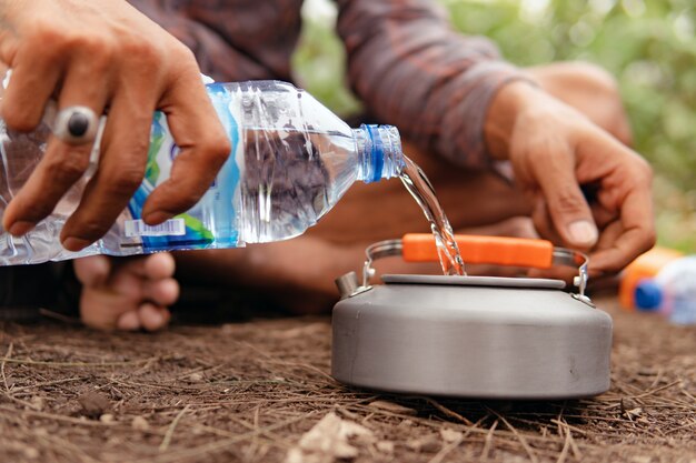 Pouring water into a kettle. bali