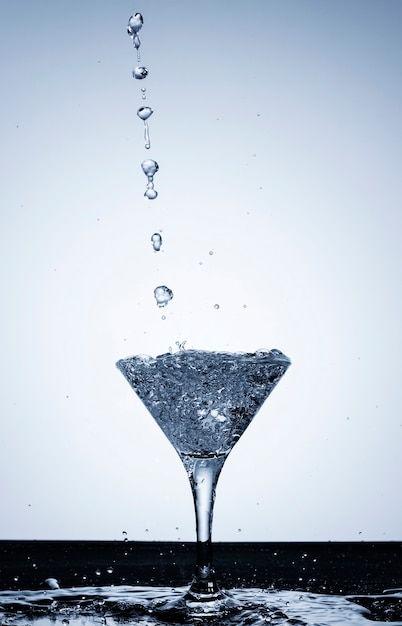 Free photo pouring water in a transparent glass close-up