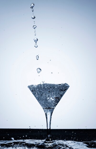 Pouring water in a transparent glass close-up