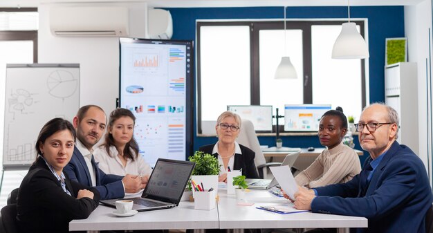 Pov of diverse team sitting in conference room during virtual meeting, discussing online with business partners