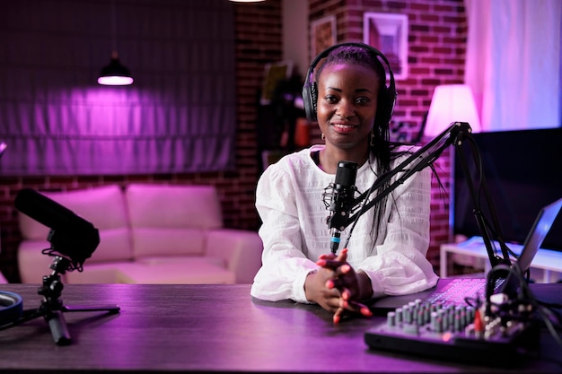 POV of female blogger filming social media podcast in studio with camera and streaming equipment. Lifestyle influencer recording video episode, having conversation with audience.