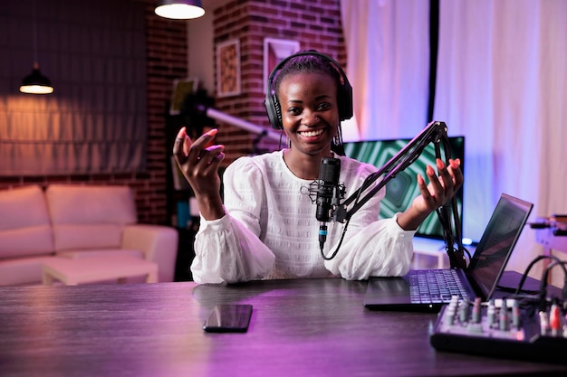 POV of female presenter greeting people on channel podcast, using camera and recording equipment in studio. Lifestyle vlogger talking to audience on social media episode, internet content.