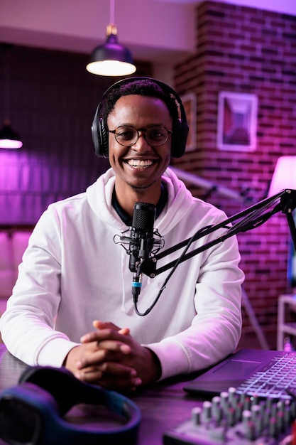 POV of male influencer recording podcast episode on camera, using sound equipment in studio. Portrait of content creator talking to audience and filming social media channel vlog.