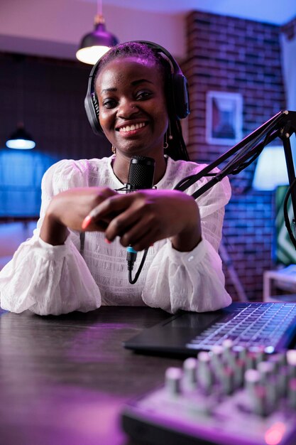 POV of woman blogger creating podcast episode in studio, recording with camera and modern sound equipment. Female vlogger filming video and talking to audience for internet channel.